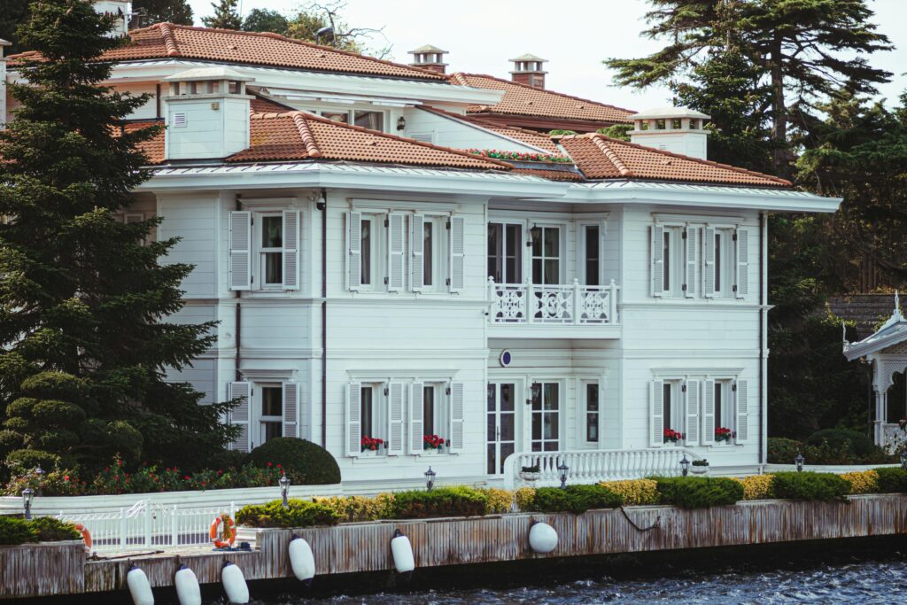 Charming white mansion with red rooftop and shutters by the Bosphorus in Istanbul, Turkey.